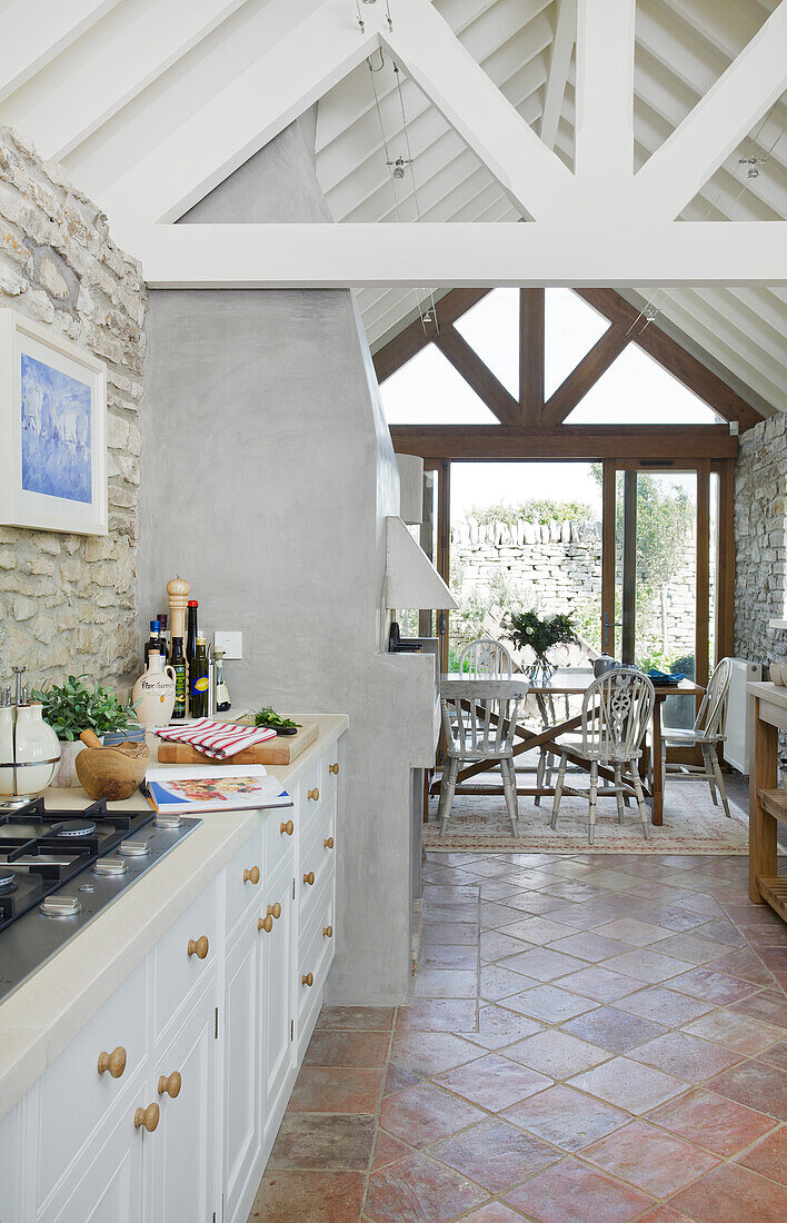 Open-plan living room with kitchen and dining room, terracotta floor