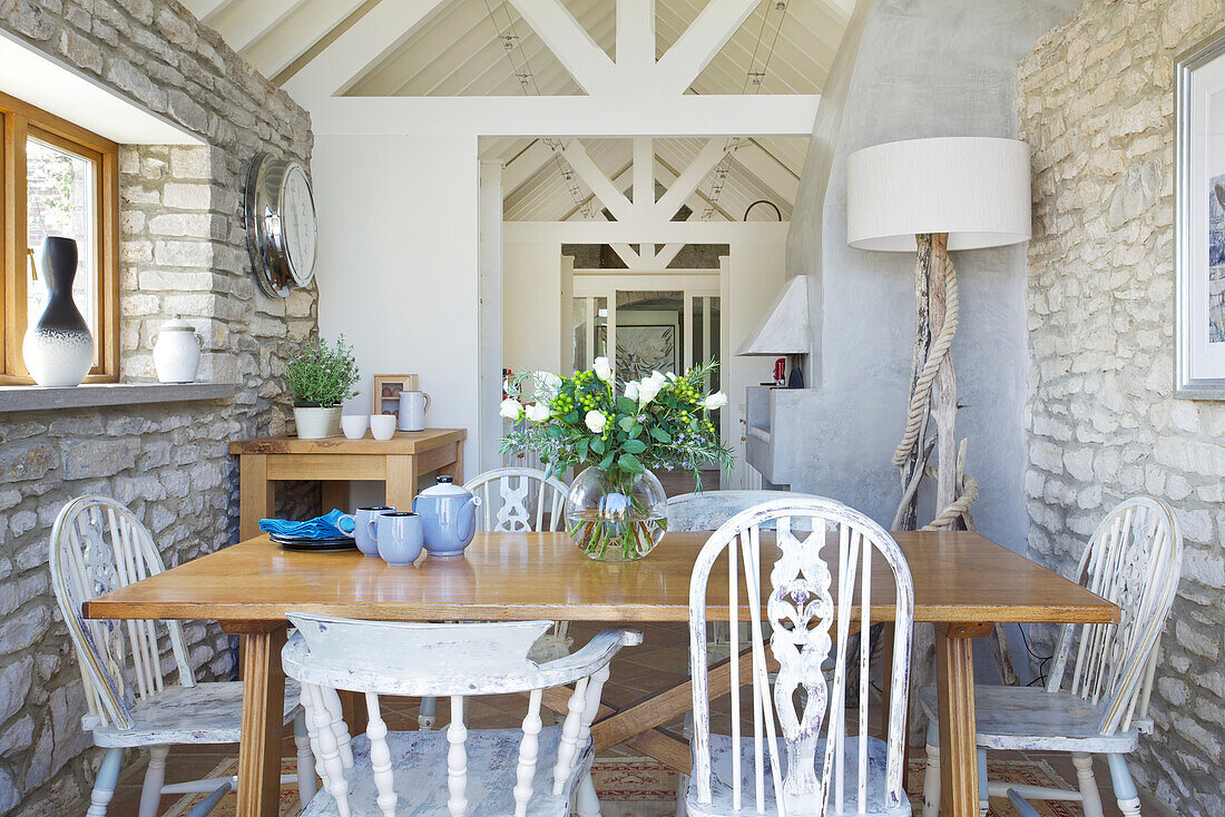 Country-style dining room with natural stone wall and wooden furniture