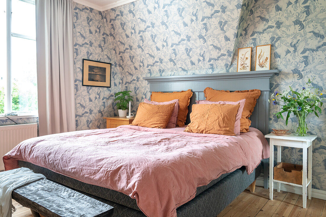 Bedroom with floral wallpaper, bouquet of flowers and pictures