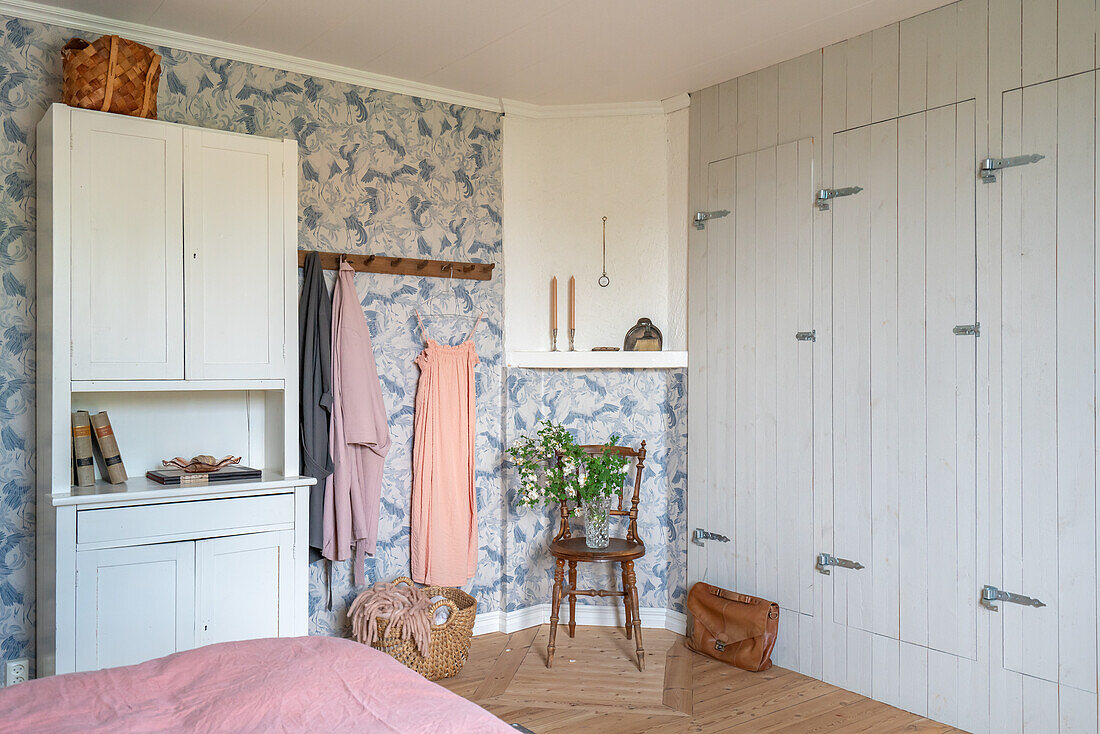 Bedroom with patterned wallpaper and fitted wardrobes