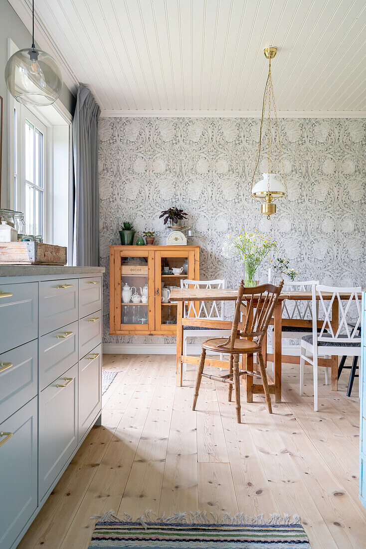 Kitchen with patterned wallpaper and wooden units