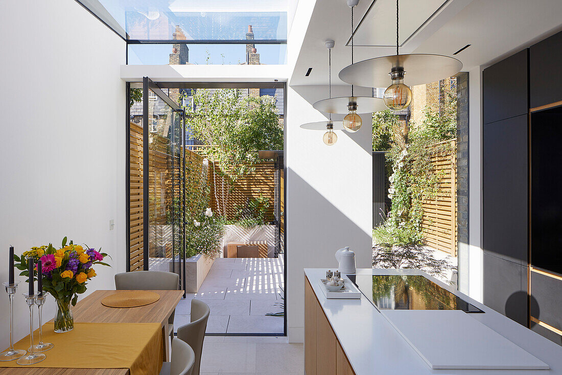 Moderne offene Küche mit Dachfenster und Gartenzugang