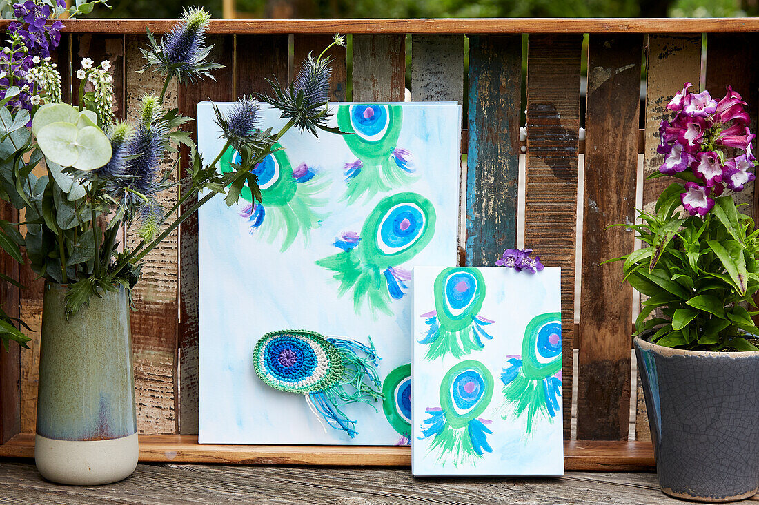 Canvases with painted and crocheted peacock feathers