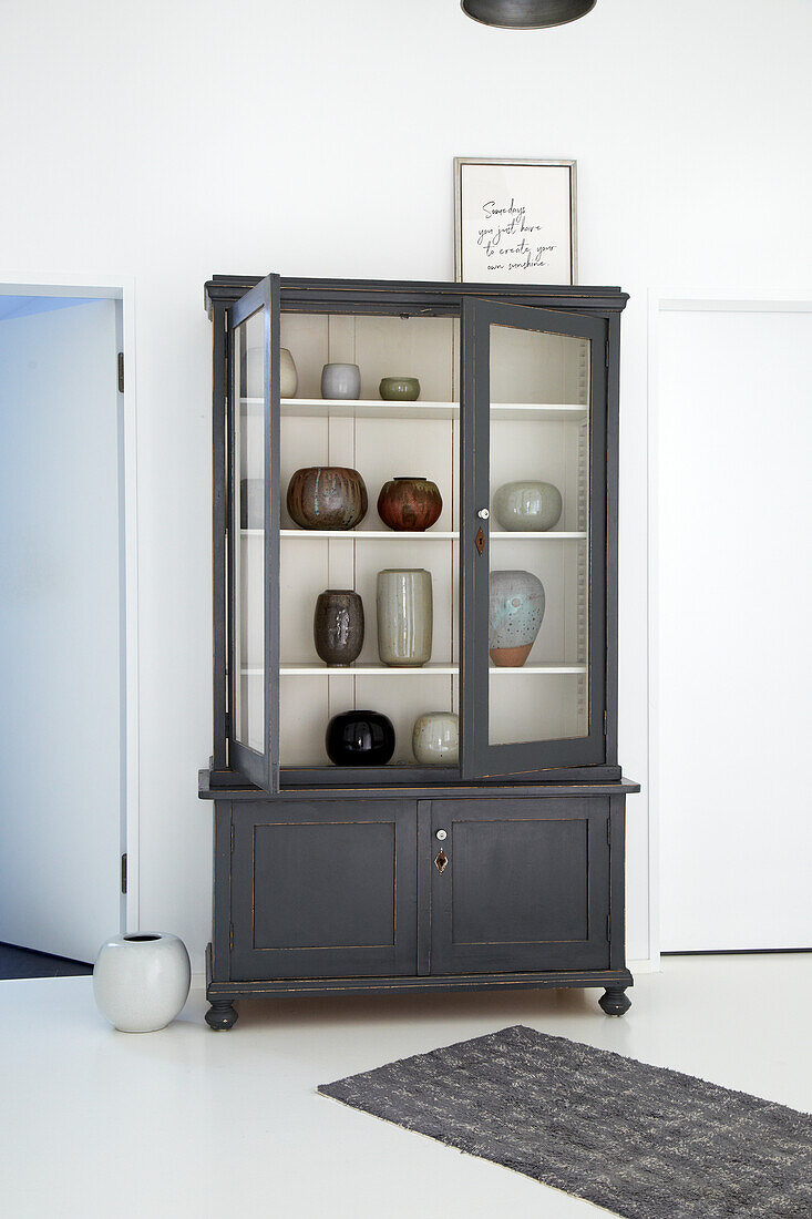 Display cabinet with ceramic vases in a minimalist room