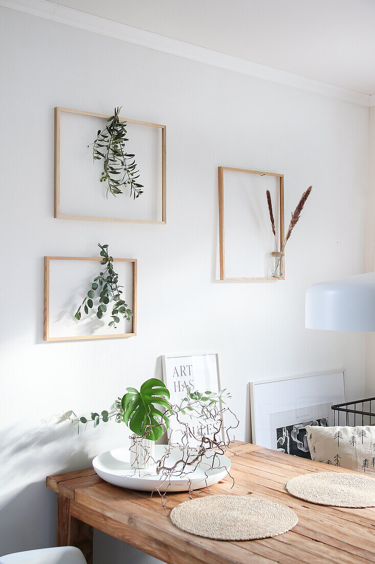 Plant branches in picture frames as wall decoration