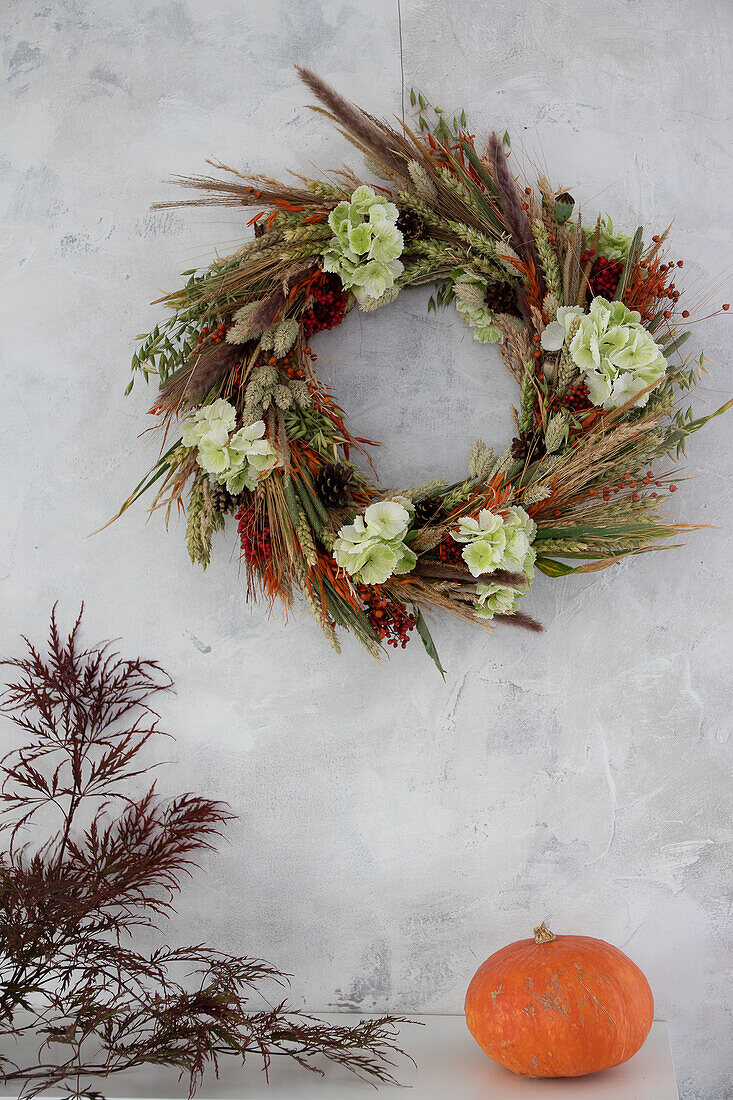 Homemade autumn wreath on a grey wall