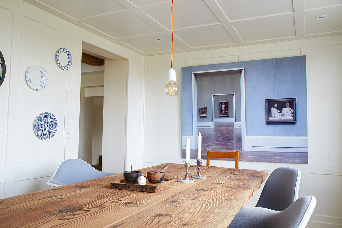 Long wooden table in the dining room with coffered wall and blue accents