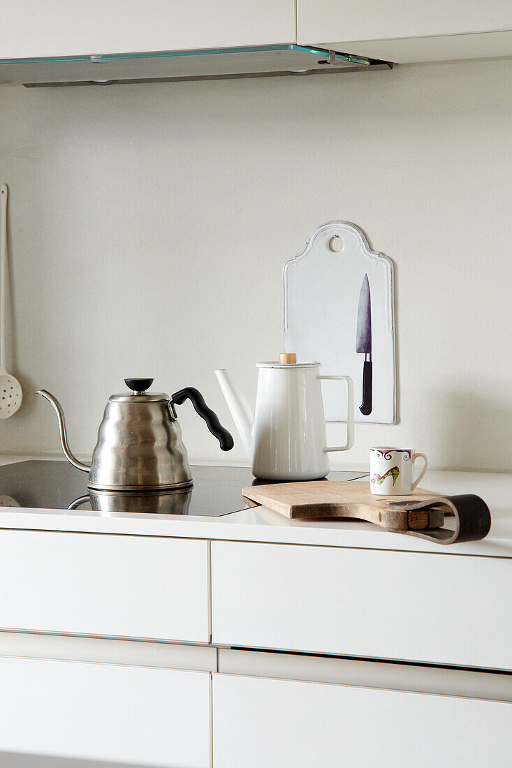 White kitchen unit with kettle and kitchen utensils