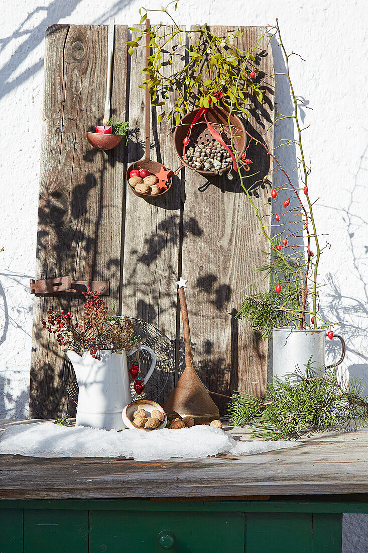 Winterliche Dekoration mit Zweigen, Beeren und Nüssen