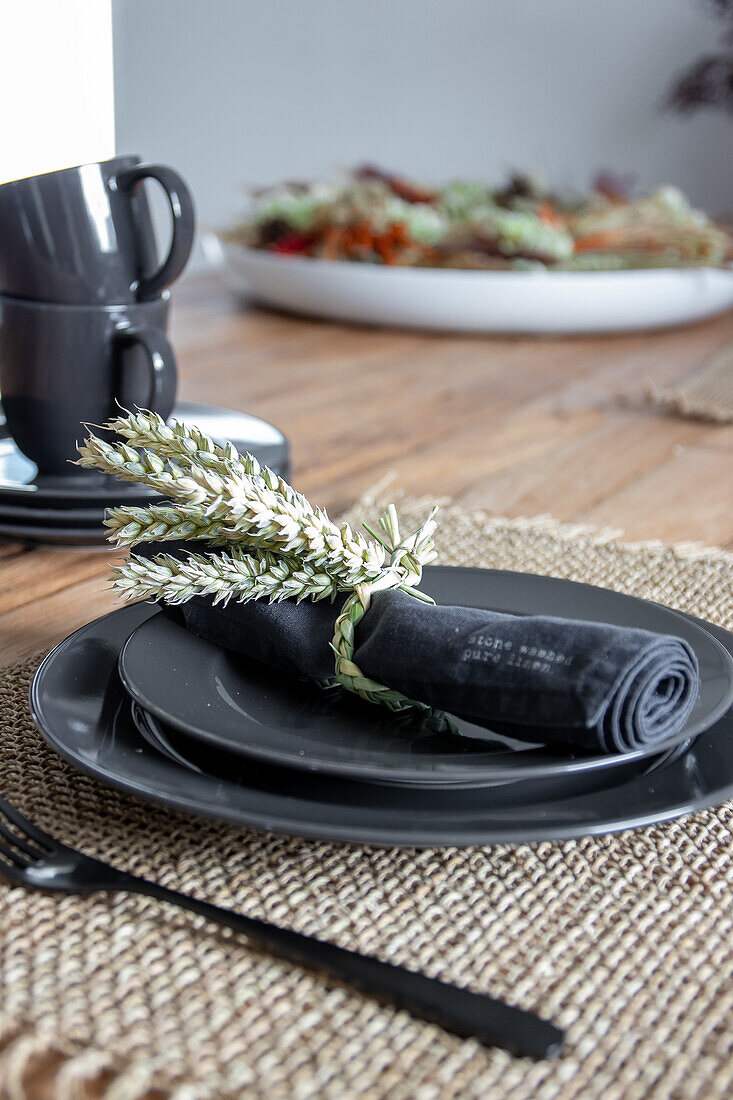 Black ceramic crockery with wheat stalk napkin ring