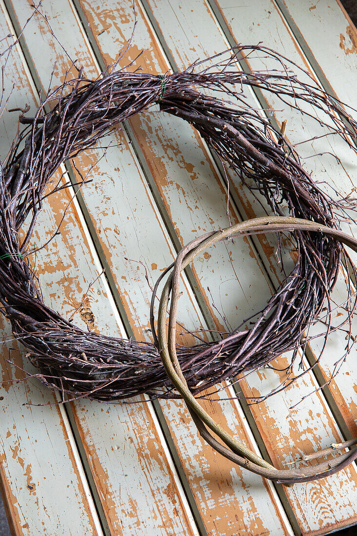 Three handmade wreath bases made from twigs on a wooden background