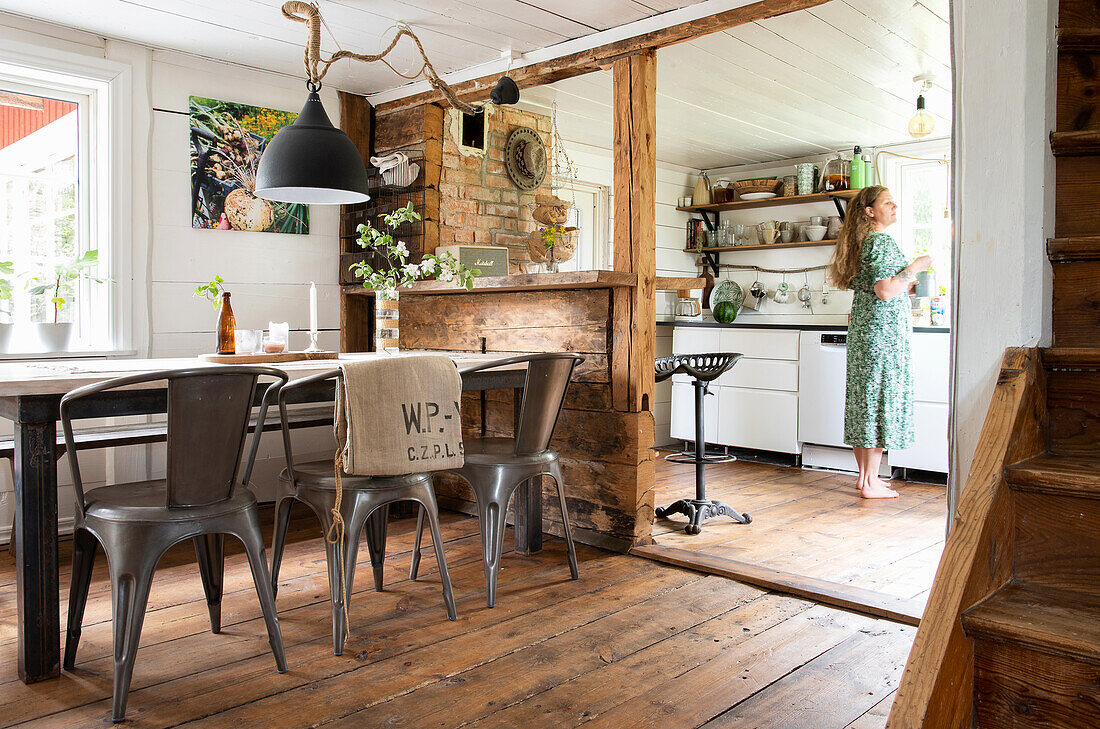 Offener Koch- Essbereich, Frau in grünem Kleid in Küche, rustikaler Wohnstil