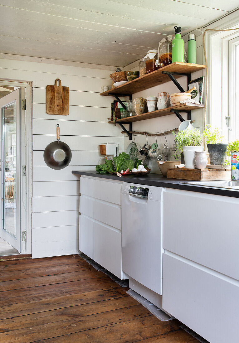 Weiße Landhausküche mit Holzboden und offenen Regalen