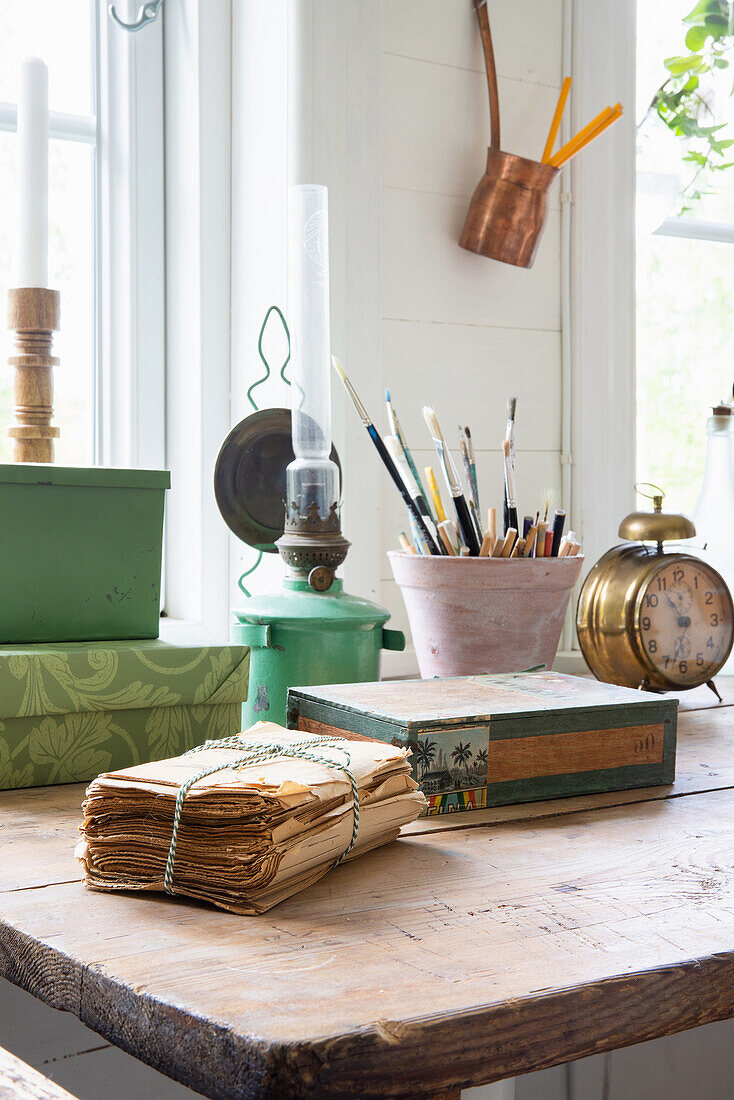 Arbeitsplatz mit Vintage-Elementen und Pinseln in Pflanztopf auf Holztisch