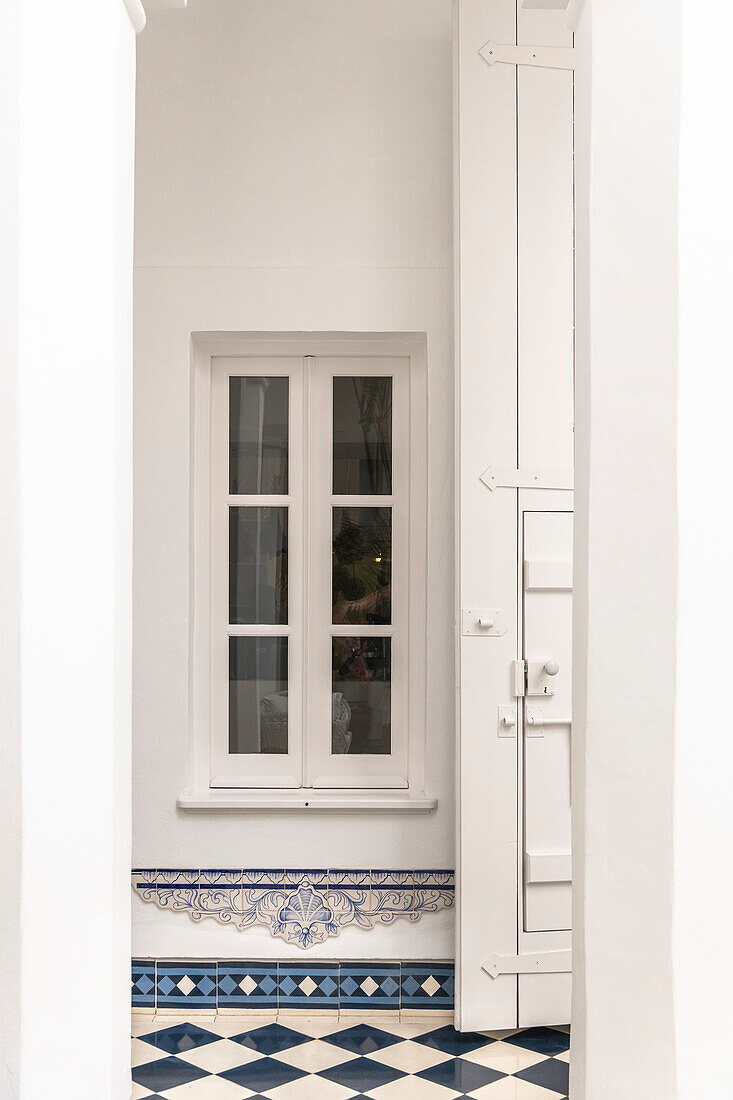 Window to courtyard and tiles with checkerboard pattern