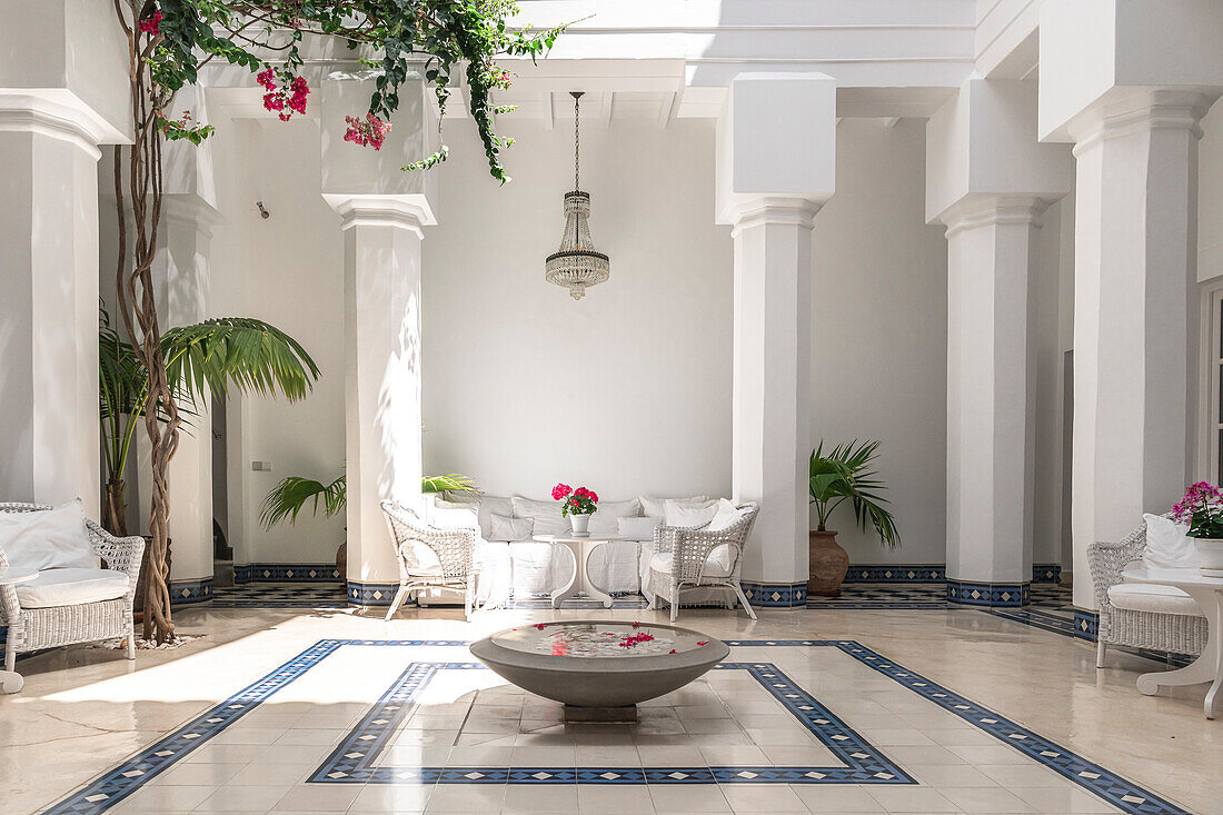 Patio with white rattan furniture, columns and tiles