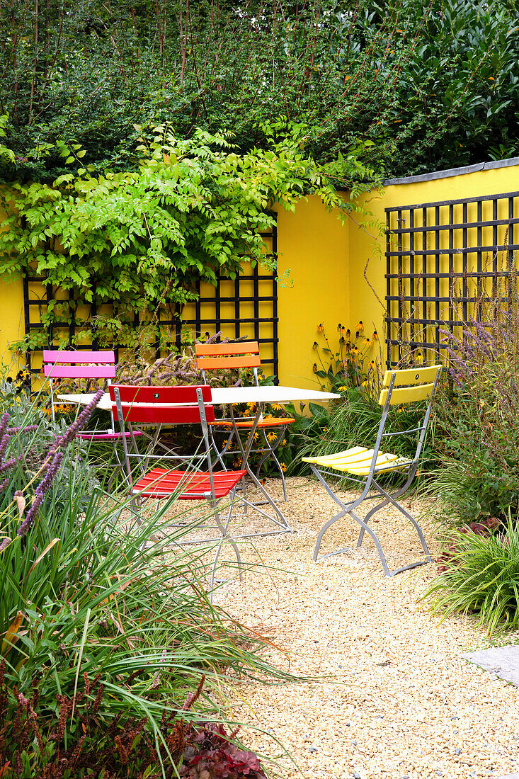 Seat in front of yellow painted wall with trellis (Appeltern, Netherlands)