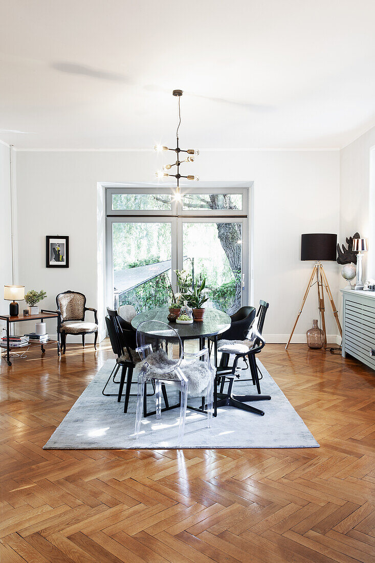 Dining room with oval table, modern chairs and parquet flooring