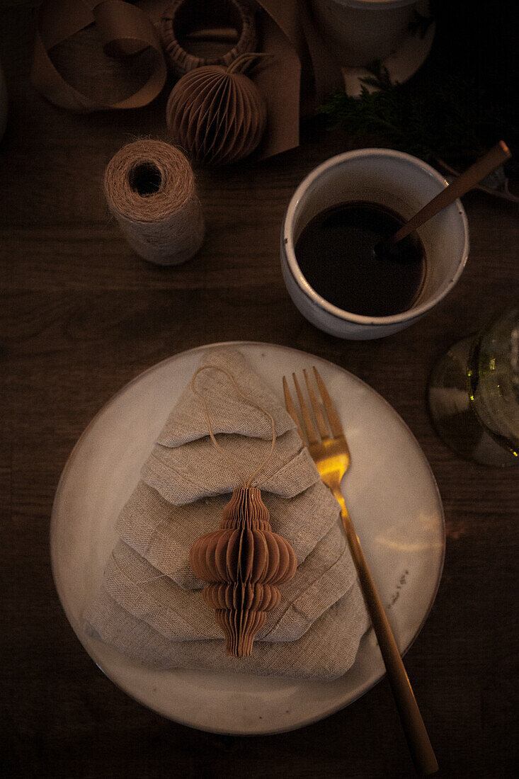 Table decoration with linen napkin and paper ornament in the shape of a cone