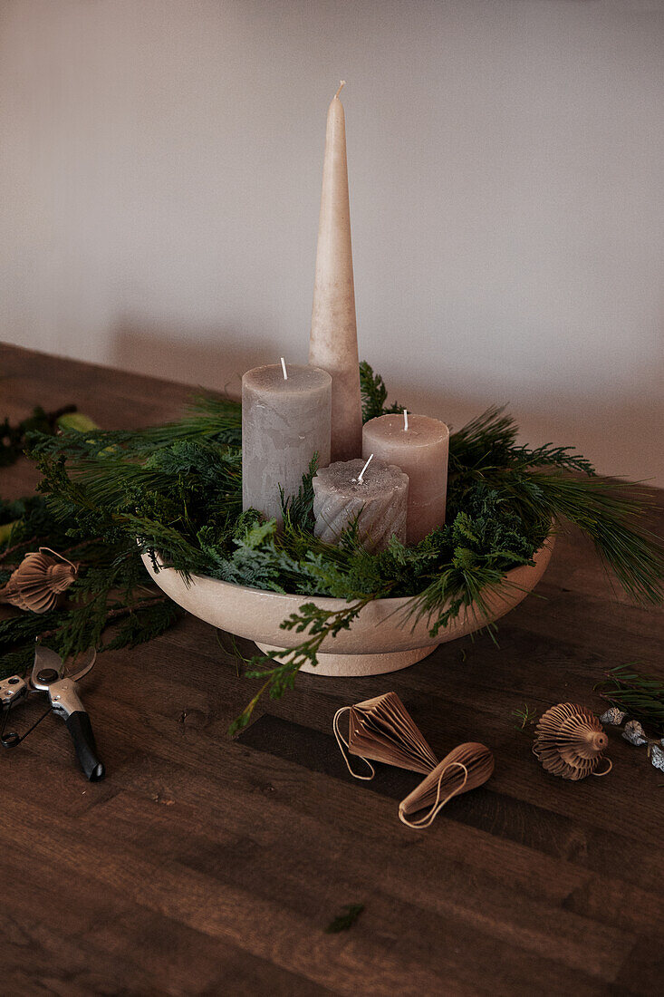 Advent arrangement with candles and greens in a bowl