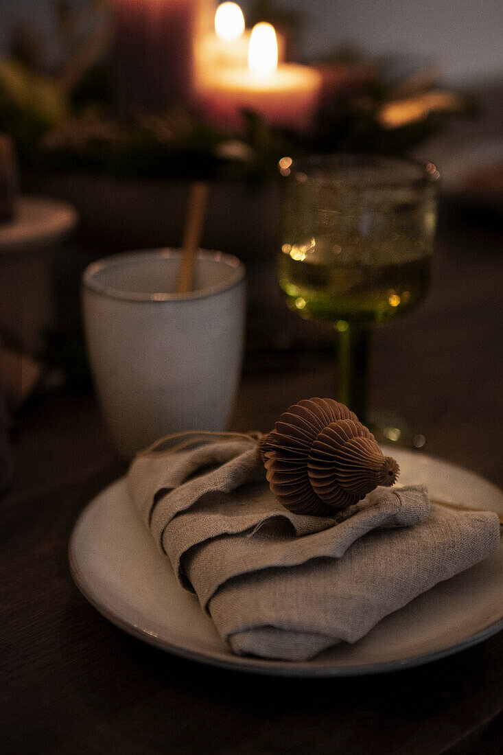 Table setting with folded linen napkin in candlelight