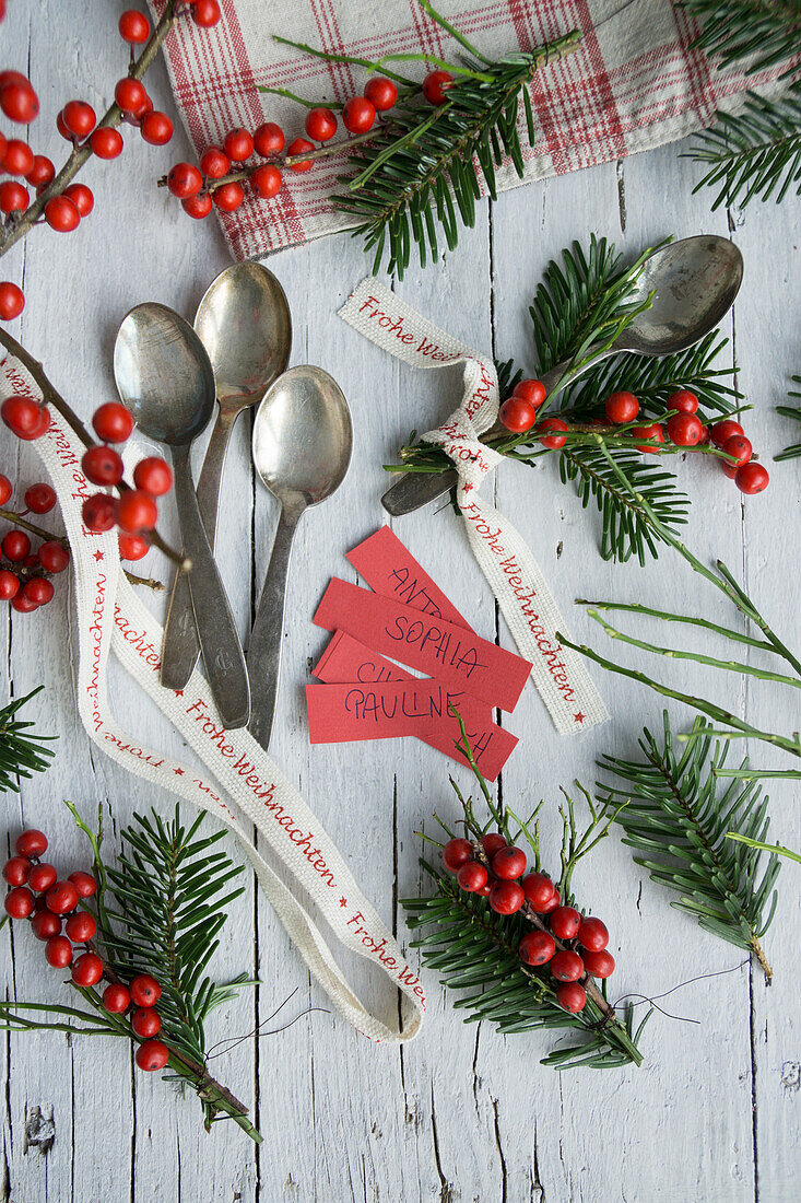 Silberlöffelchen mit Namensschildchen, Ilexsträußchen und Weihnachtsband