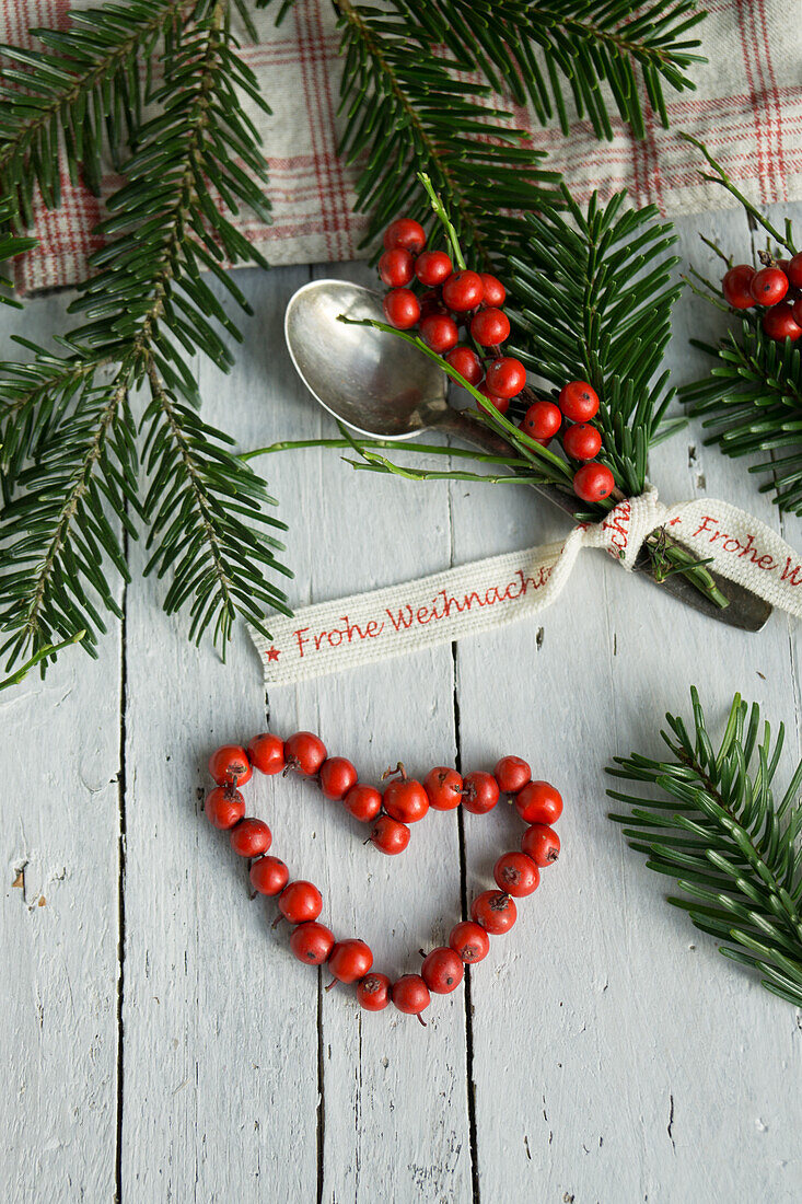 Silberlöffelchen mit Ilexsträußchen und Weihnachtsband, Herzform aus Ilexbeeren
