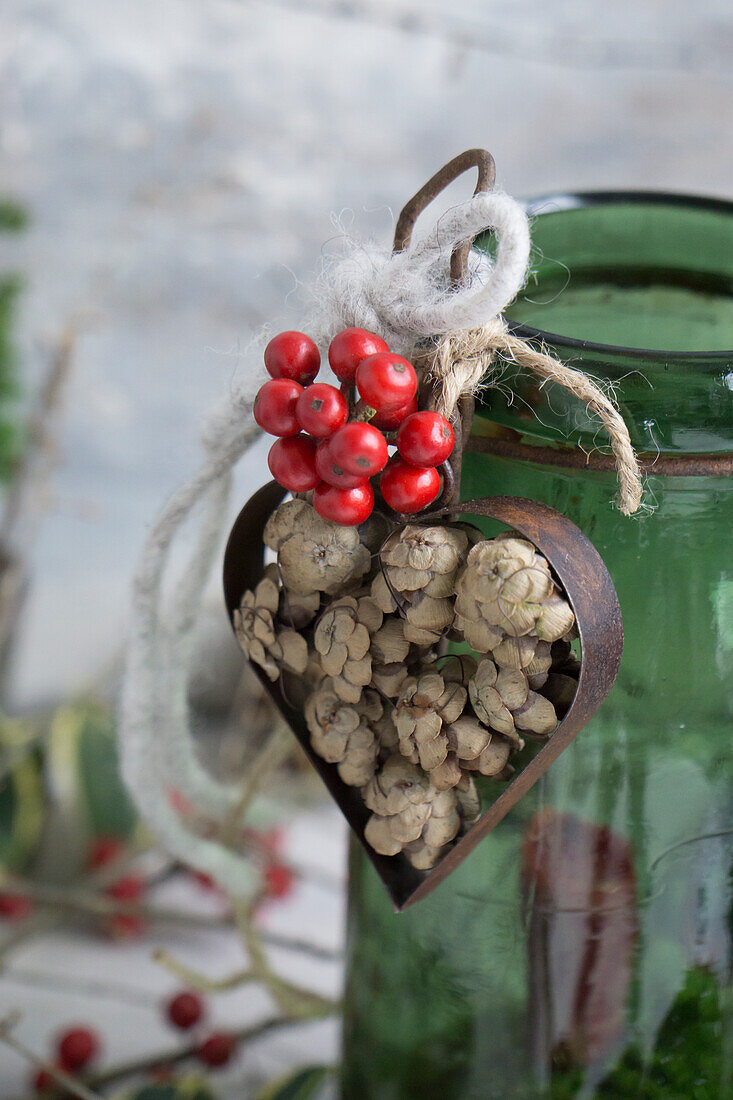 Heart cookie cutter filled with hemlock cones and holly on vintage hanger glass