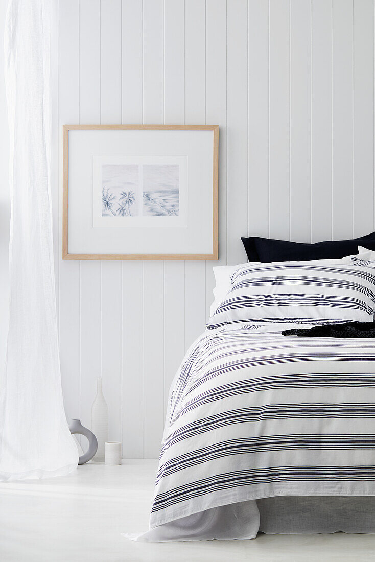 Schlafzimmer im Küstenstil mit weiß getäfelten Wänden, Vorhang und weißem Boden