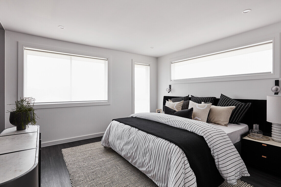 Monochromes Schlafzimmer in Schwarz und Weiß mit Kingsize-Bett und schwarzem Fußboden