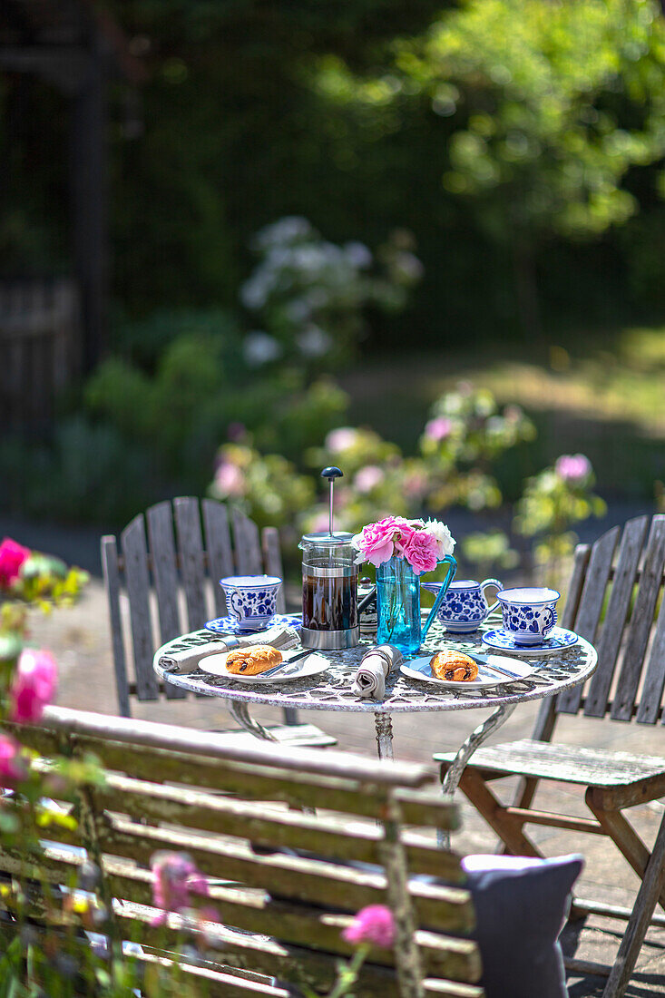 Vintage Tisch mit blau-weißem Geschirr und Gebäck auf der Terrasse