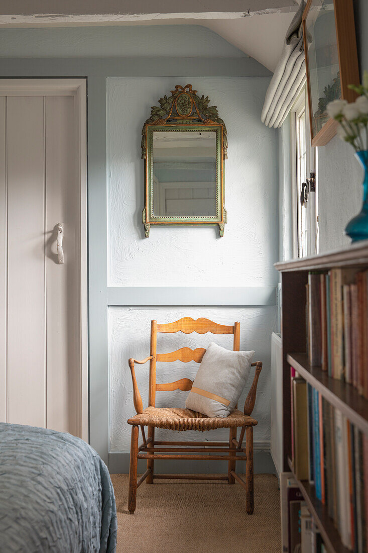 Armlehnstuhl im Shaker-Stil, darüber Spiegel im im Schlafzimmer in Hellblau und Weiß