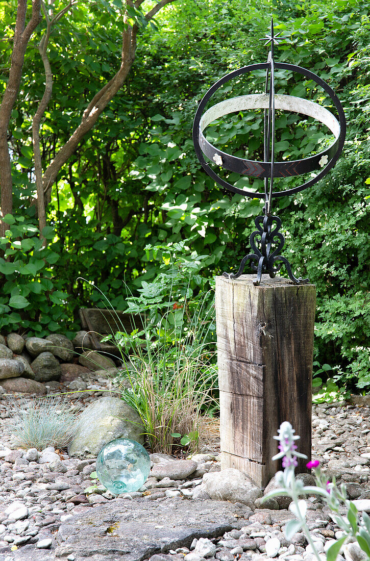 Sundial on a thick tree trunk in the garden