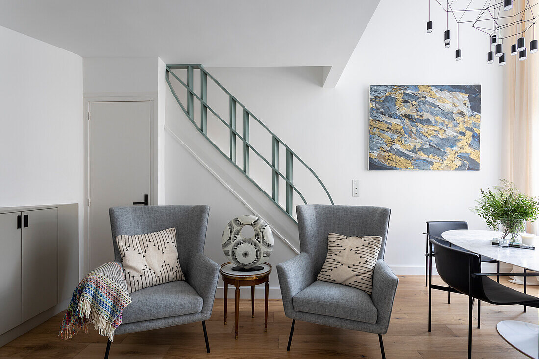 Hellgraue Polstersofas mit Beistelltisch vor Treppe in einer Maisonette-Wohnung