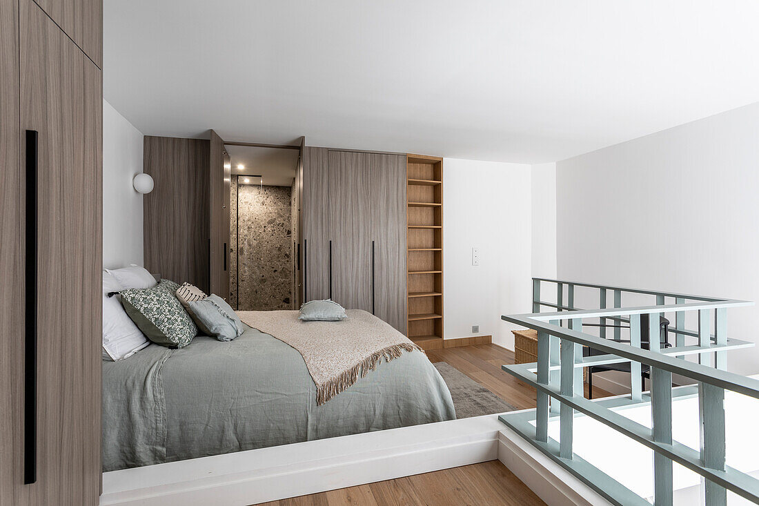 Open bedroom with queen bed, ensuite bathroom in the background in a maisonette flat