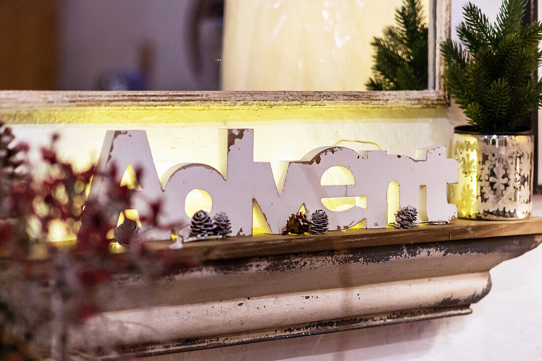 Schriftzug 'Advent' aus weissem Holz vor einem Spiegel