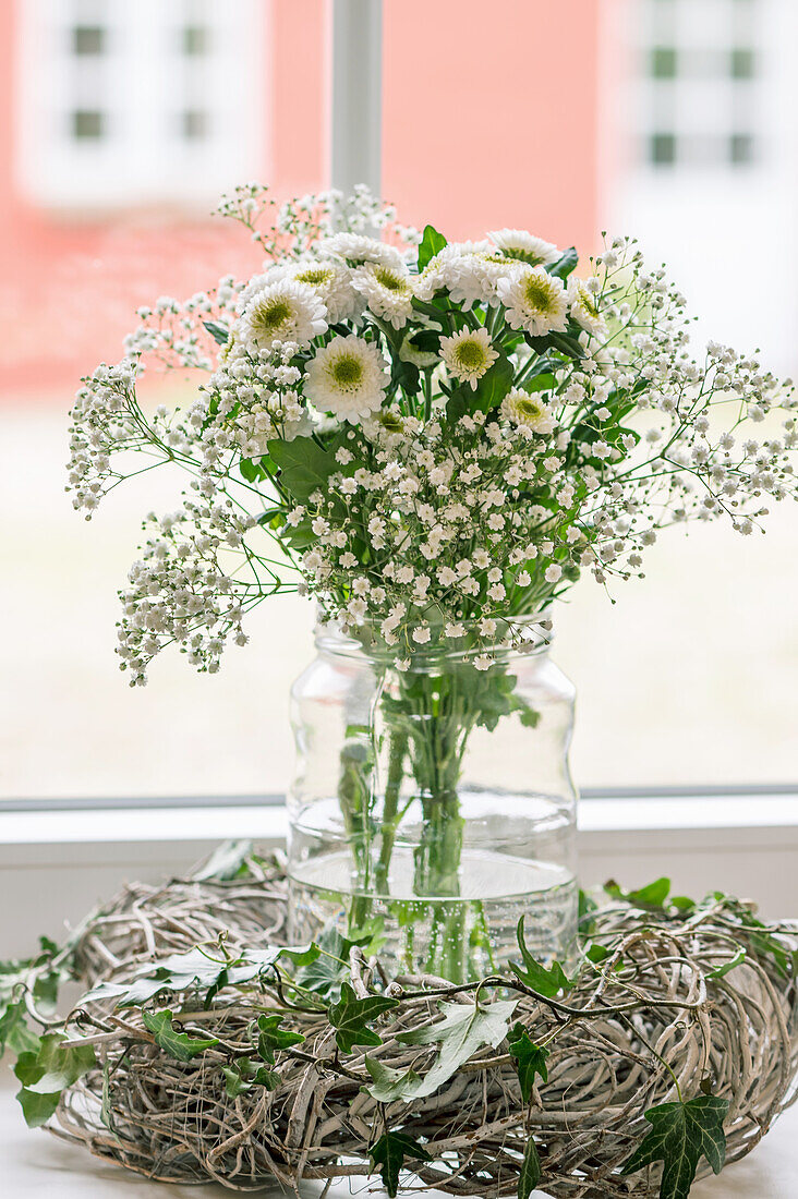 White bouquet in a vase in front of a window