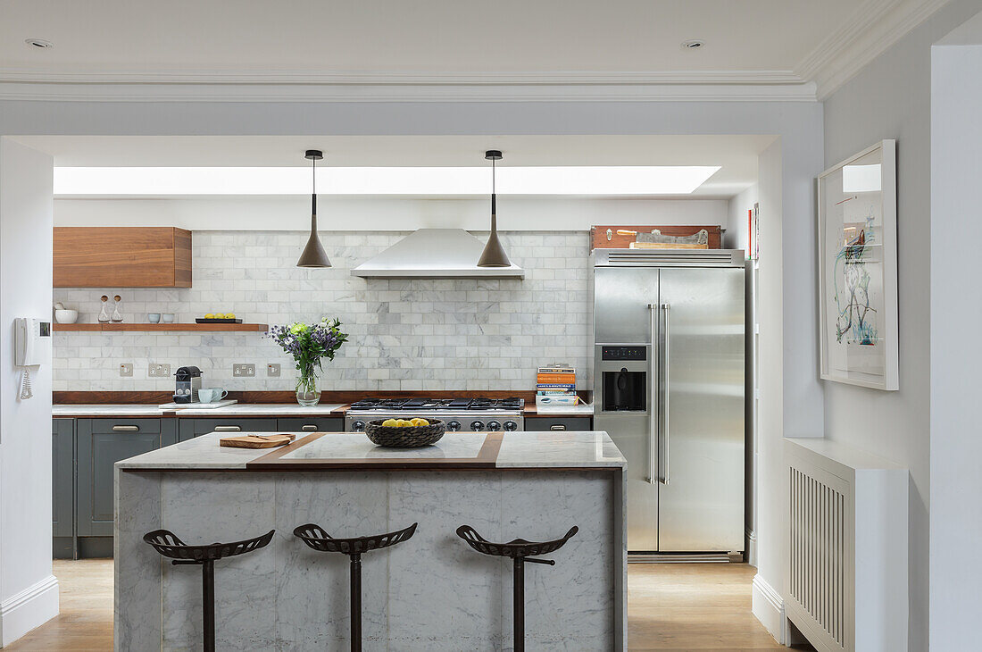 Bright kitchen, in the foreground kitchen island with marble sides