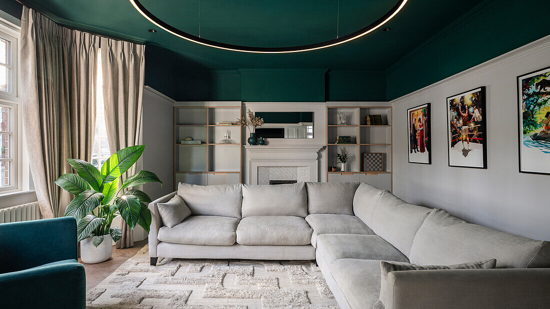 Cozy TV room with upholstered sofa and green ceiling