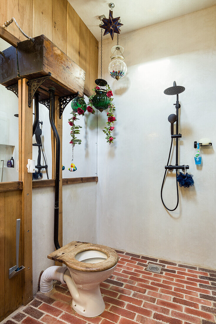 Toilet and ground level shower with brick floor