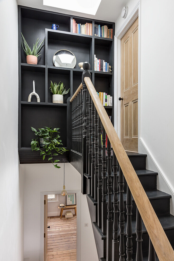 Staircase with black staircase and turned balusters, black built in shelf on landing