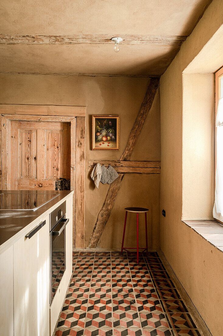 Cement tiles in 3D look in kitchen with exposed post and beams in an old country house