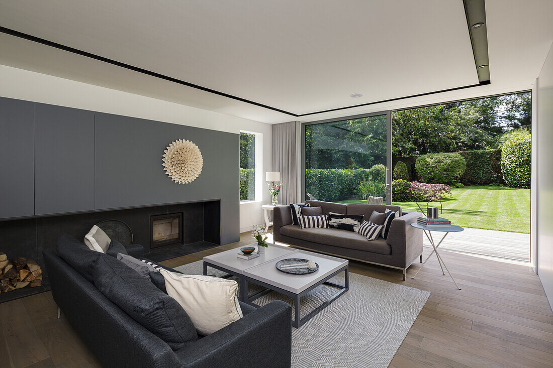 Open plan living room in grey tones, with couches and a fireplace