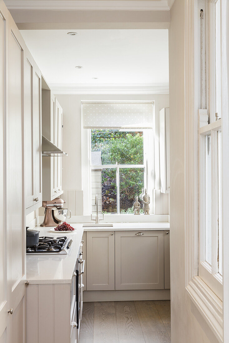View into bright fitted kitchen with a window