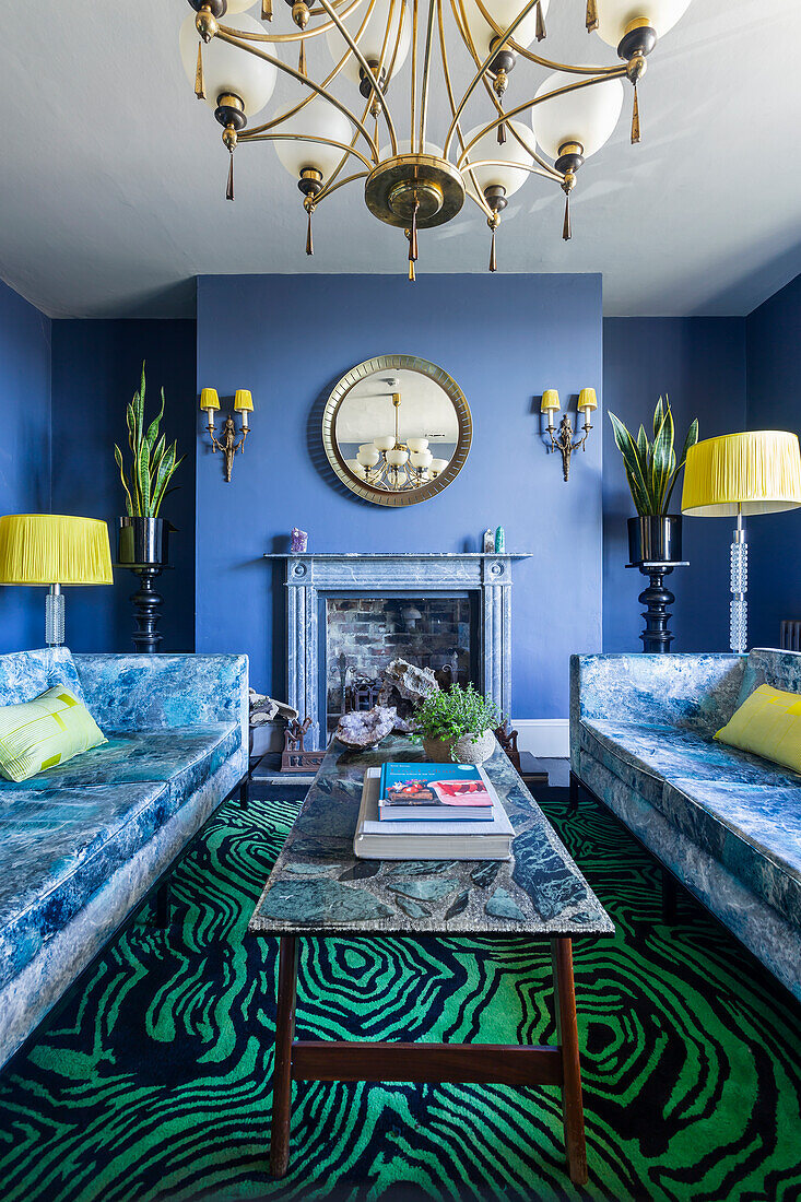 Sofas with marbled fabric design, coffee table with marble top and carpet with malachite pattern in living room with blue walls
