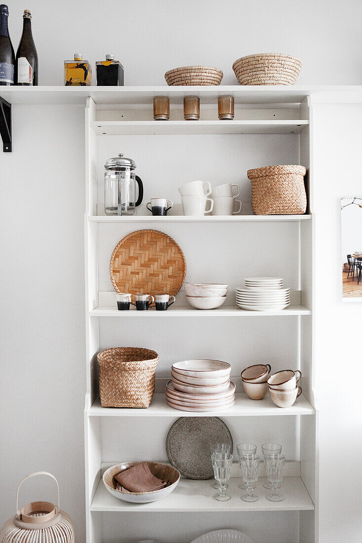Küchenregal mit beige-braunem Geschirr an weißer Wand
