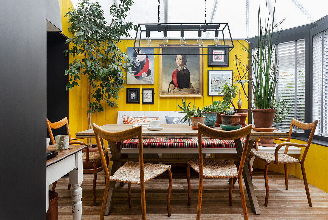 Dining area in the conservatory, artwork on yellow wall