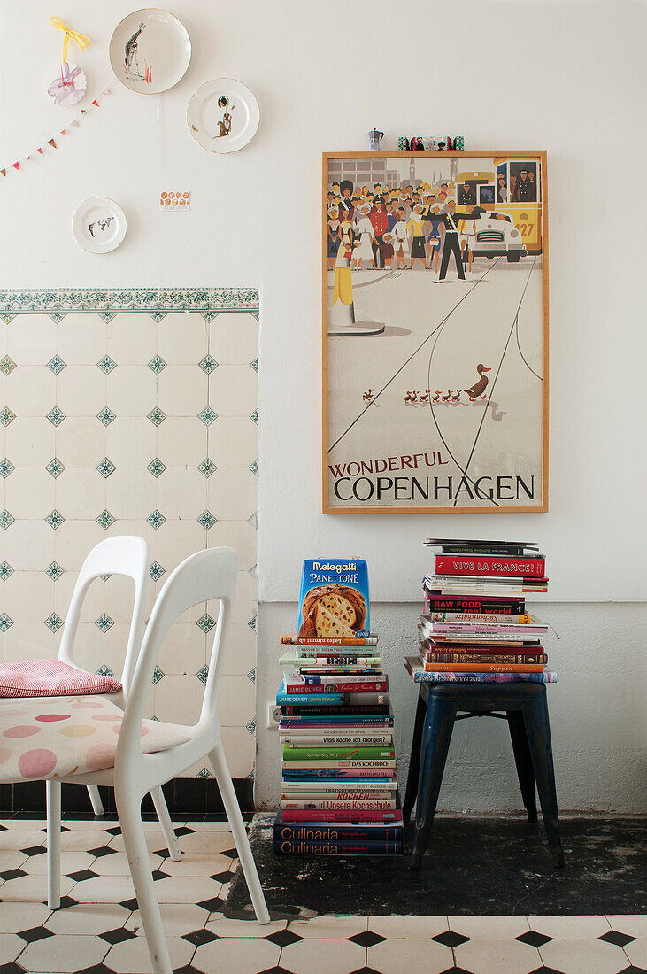 Stack of books, above vintage poster in the kitchen