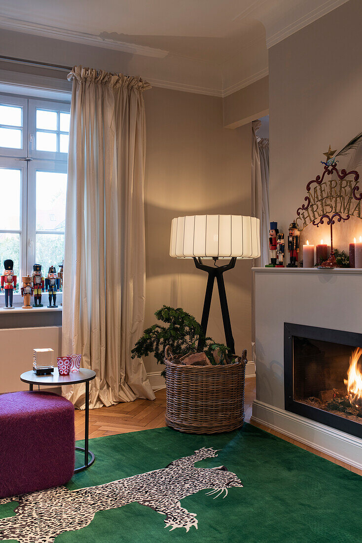 Silk carpet with leopard skin design in front of fireplace, designer floor lamp in room corner