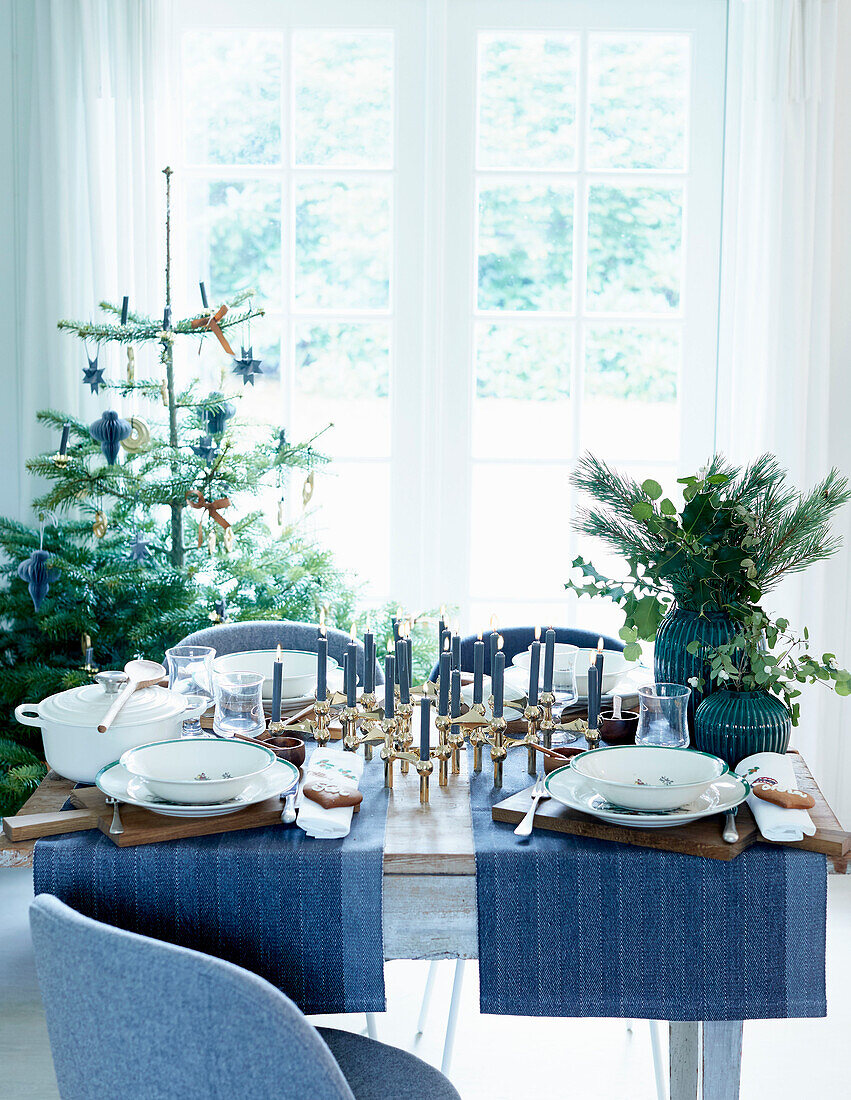 Festlich gedeckter Weihnachtstisch mit zwei blauen Tischläufern